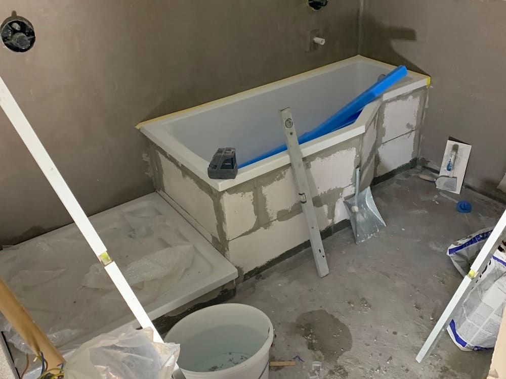 Badezimmer im Rohbauzustand: Wanne eingesetzt, Wände unverputzt, Baustelle